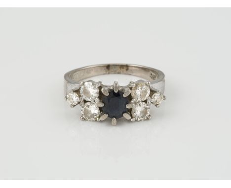 RING Weißgold. Ringmaß ca. 56,5, Ges.-Gew. ca. 6 g. Gest. 585, nummeriert. Ein rund facettierter Saphir, ca. 0,94 ct., sechs 