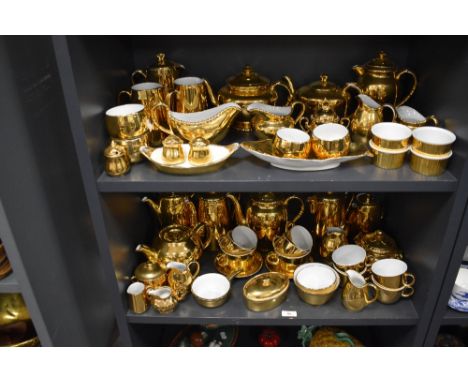 Two shelves of modern Royal Worcester porcelain tea wares having gilt glaze over porcelain