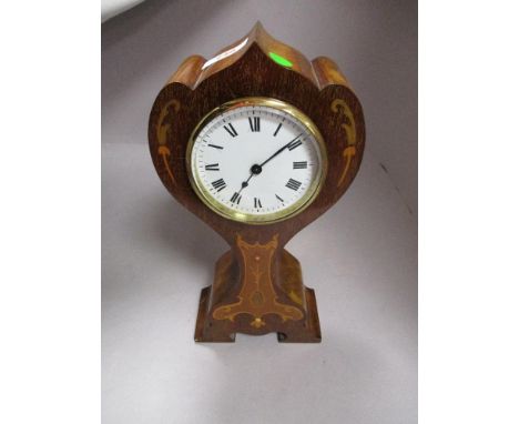 An early 20th century mahogany balloon clock having enamel face with Roman numerals and inlaid satinwood detailing.