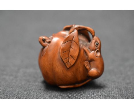 An early 20th century Japanese carved wood Netsuke of two mice eating a Pumpkin