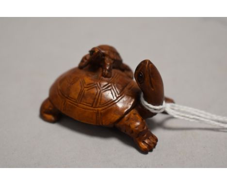 An early 20th century Japanese carved wood Netsuke of a mother tortoise with a baby climbing upon its back
