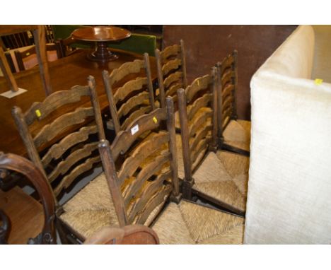 A set of six oak ladder back and rush seated dining chairs