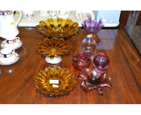 A quantity of various coloured glassware to include paperweights and a handkerchief vase 