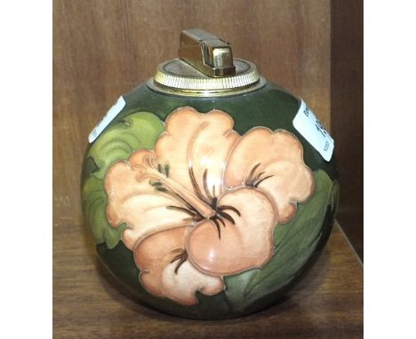 A Moorcroft ball-shaped green-glazed table lighter decorated in the Hibiscus pattern, paper label to base, 11cm high.