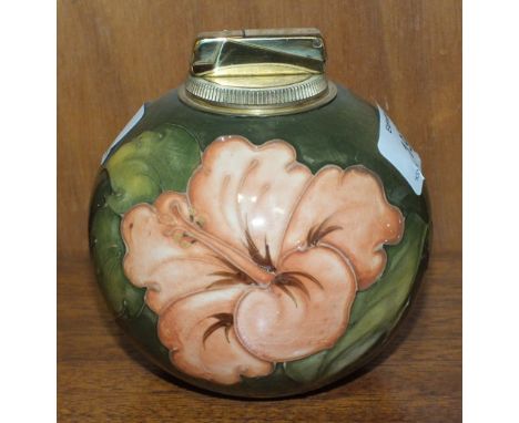 A Moorcroft ball-shaped green-glazed table lighter decorated in the Hibiscus pattern, paper label to base, 11cm high.