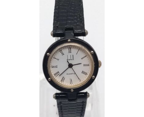 A vintage circular white face quartz dunhill watch with leather strap. Needs new batteries. 21cm length. 30mm diameter. 