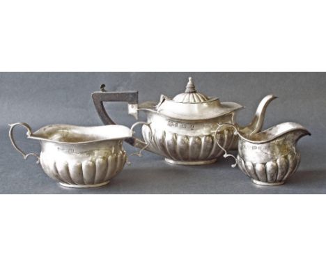 Edwardian silver half fluted bachelor tea service comprising boat-shaped teapot, milk jug and twin handled sucrier, maker Wil