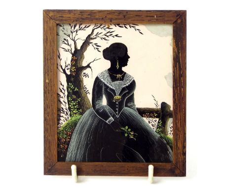 19th Century School - silhouette study of a lady seated in a garden setting, reverse work on glass, inscription verso 'Antiqu