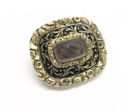 Early 19th century gold and enamel mourning brooch, with a glazed hair locket in a foliate surround, the reverse with a glaze