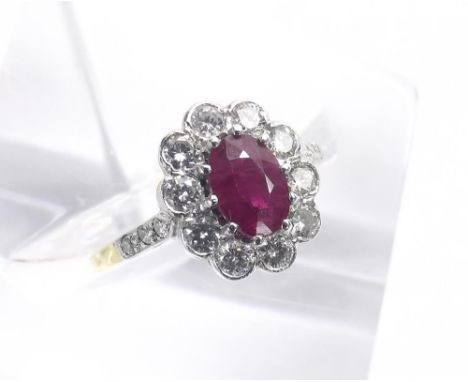 Ruby and diamond oval cluster ring in 18k yellow and white gold with set shoulders, the ruby 1ct approx, round brilliant-cut 