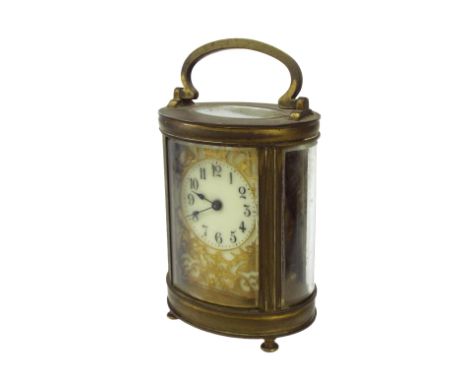 Brass oval carriage timepiece, with gilt filigree work to the enamel face, 6.5" high