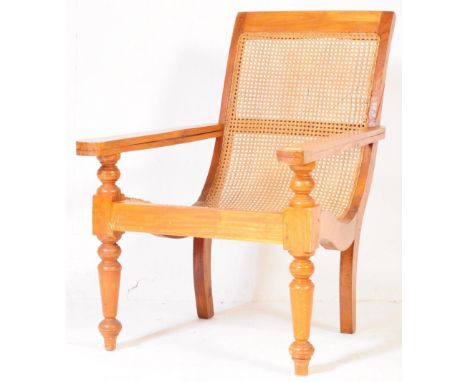 A retro vintage mid 20th century plantation wicker arm chair. Having a rectangular back rest with wicker cane work to back an