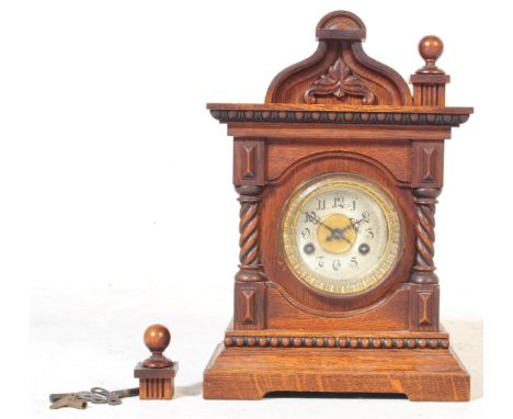 A 19th century Victorian century mahogany eight day mantel clock. With arched centre top flanked by finial (af) with a silver