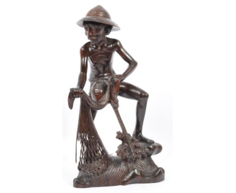 A 20th century Chinese hardwood hand carved figure in the form of a fishing man. Well carved detailing, the fisherman hauling