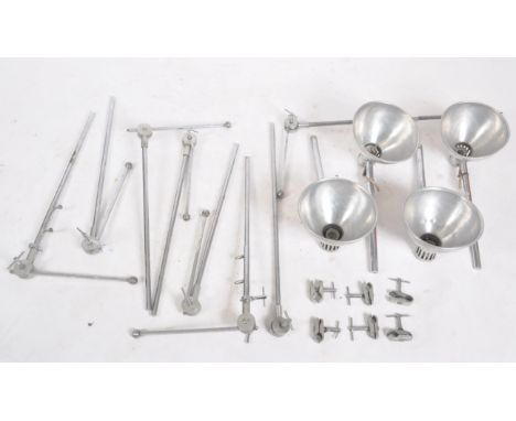 A selection of four 20th century industrial spot lamp lights each with a polished aluminium shades on articulated polished st