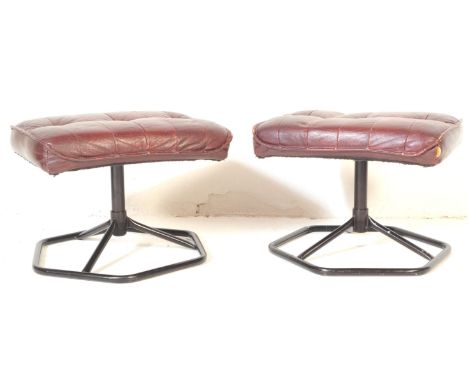 A pair of 20th century footstools / ottomans. The footstool each being upholstered in a burgundy leather fabric atop, raised 