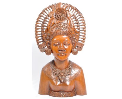 A 20th Century tribal hand carved Balinese figurine bust depicting a female deity of princess having an ornate crowned headdr