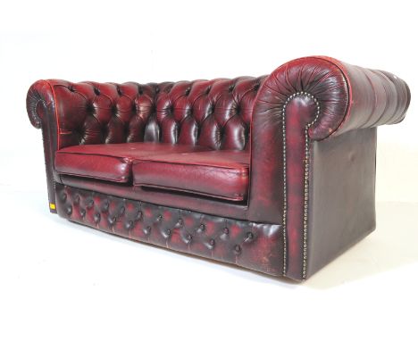 An early 20th century ox blood leather Chesterfield sofa settee couch. The sofa having button back decoration to back and arm