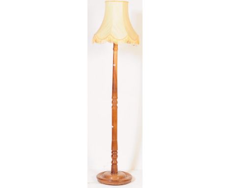 A 1930s / 1940s 20th century mahogany standard, floor standing lamp light. Having a beige material lamp shade with a central 