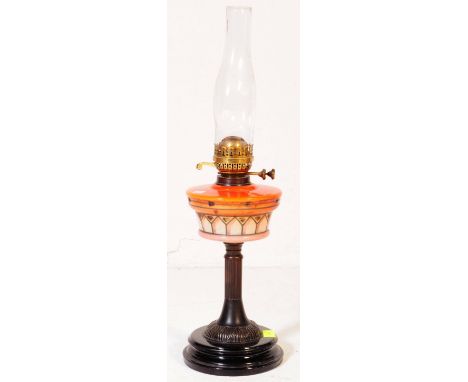 A Victorian 19th century English glass and brass oil lamp. With brass fixings, glass orange red reservoir with ebonised centr