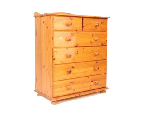 A retro vintage 20th century country style pine chest of drawers. The chest is in a 2 over 4 configuration with turned wooden