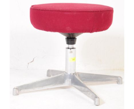 A vintage, retro aluminium swivel stool / ottoman in the manner of Charles Eames. The swivel chair with plush burgundy uphols