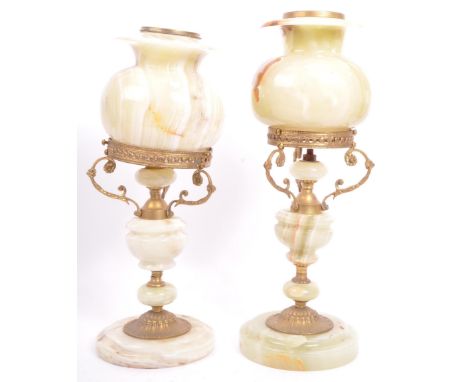 A pair of 20th century Italian onyx and gilt metal table lamps. The lamps being in the form of an oil lamp with pierced flora