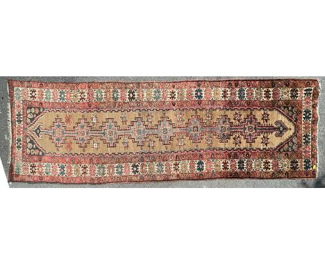 An early 20th century Anatolian hand knotted runner carpet rug. The rug having beige ground with pink and blue bukagi and yil