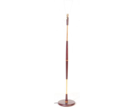 A retro vintage mid 20th century Danish inspired floor standing standard brass copper and wooden lamp. having tapering wooden