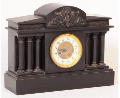 A 19th century Victorian slate and marble 8 day mantel clock. Having a central arched top with sloping sides with mounted fro