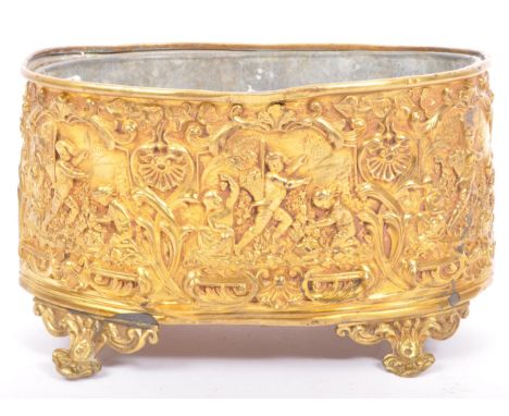 A 19th century French repousse brass planter cache pot being decorated with floral and figurative scenes raised over ornate r