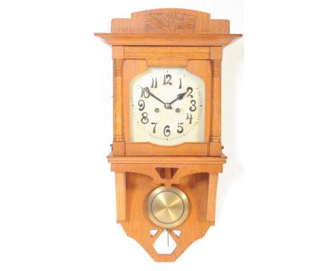 A vintage 20th century German wood hanging wall clock. With carved shaped detail to top with silver face and ebonised chapter