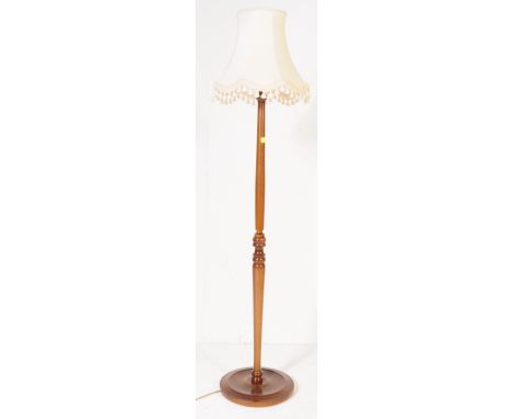 An early 20th century circa. 1920's floor standing standard lamp. The lamp having turned wood shaft raised over circular base