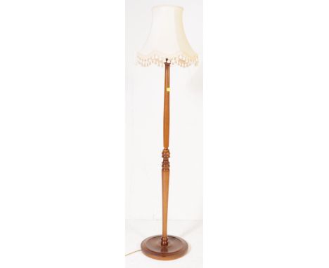 An early 20th century circa. 1920's floor standing standard lamp. The lamp having turned wood shaft raised over circular base