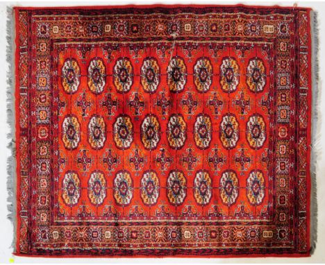 A 20th century Persian / Islamic Woollen Bokhara floor rug carpet. The rug with a central&nbsp; red ground and multiple medal