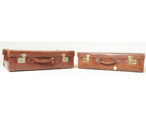 Two mid 20th Century vintage brown leather travel suitcases / trunks with mounted corners, exposed stitching and metal clasps