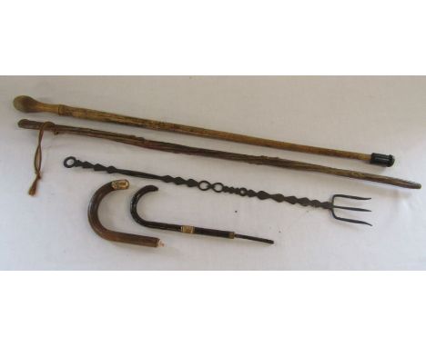 2 walking sticks, a toasting fork, umbrella handle and stick handle
