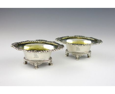 A pair of William IV silver salt cellars, by Paul Storr, London 1835, oval form, gadroon and shell borders, gilded bowls, on 