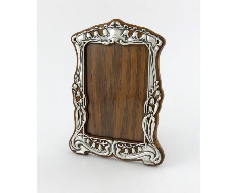 An Edwardian silver Art Nouveau photograph frame, by Walker and Hall, Sheffield 1904, shaped upright rectangular form, pierce