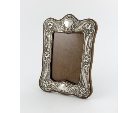 A silver Art Nouveau photograph frame, by W. J. Myatt and Co, Birmingham 1910, shaped upright rectangular form, with stylised