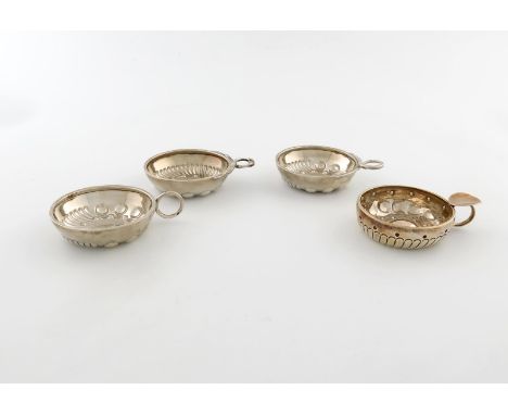 A collection of four French silver wine tasters, circular form, punch and fluted decoration, snake ring handles, three set wi