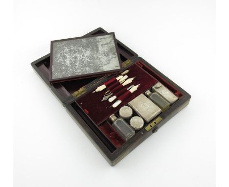 λ A Victorian silver-mounted travelling vanity set, by Frances Douglas, London 1852, comprising: six glass dressing table jar