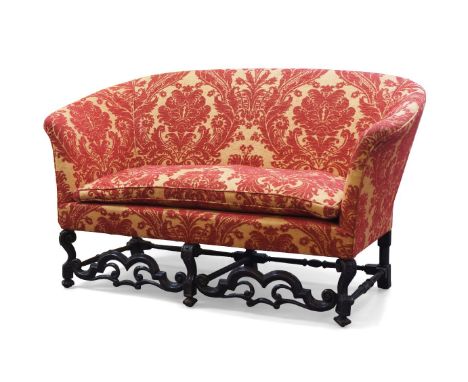 An 18th century French oak framed sofa, recently upholstered in a Zoffany chenille damask fabric, raised on carved scrolling 