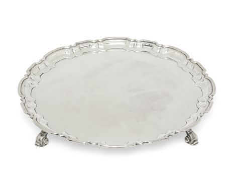 A silver salver with Chippendale style border, Birmingham, 1940, William Suckling, raised on four scroll feet, 26.7cm dia., a