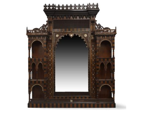 A North African over mantle mirror, possibly Syrian, circa 1900, with carved finials and moulded cornice, above pierced friez