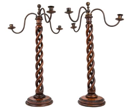 A pair of English oak and beech barley twist three-light candelabra, early 20th century, each with scroll branches, knop fini