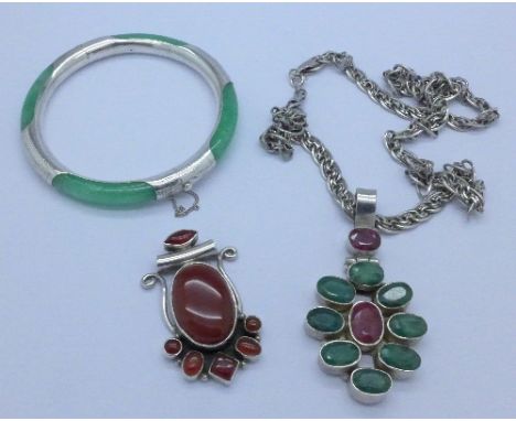 A silver and stone set pendant and chain, a silver stone set pendant and a silver and jade bangle