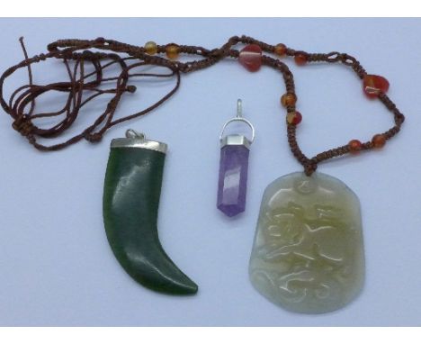 A carved jade pendant, a hardstone pendant and an amethyst and silver pendant