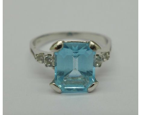 An 18ct white gold ring set with blue topaz, 3.54 carat weight and four white stones, weight 3.6g, R, with insurance valuatio