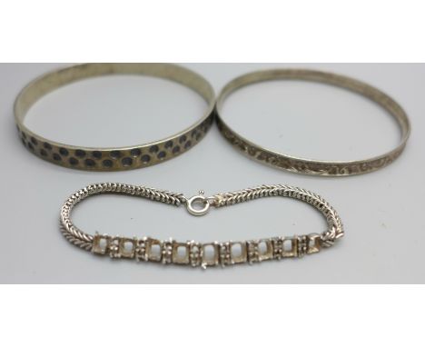 An 830 silver bangle, a silver bangle with hammered design, makers mark KT, and an unmarked bracelet lacking stones, 38g 